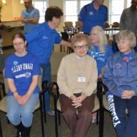 Volunteers and seniors sit together at the event.